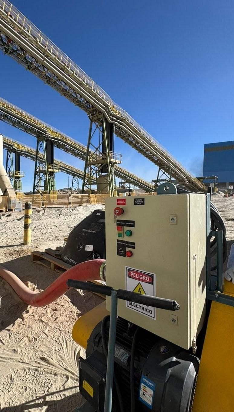 Equipo móvil de succión con tablero eléctrico junto a cintas transportadoras